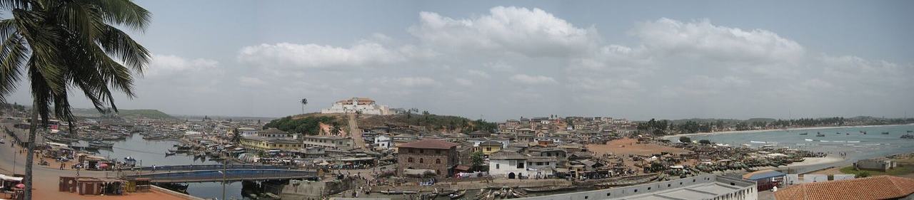 City Panorama Elmina City, Ghana. In habour some fishing boots may be seen. The picture has been taken from Elmina Castle (St. George's Castle). The castle on St. Jago Hill is Fort Conraadsburg.