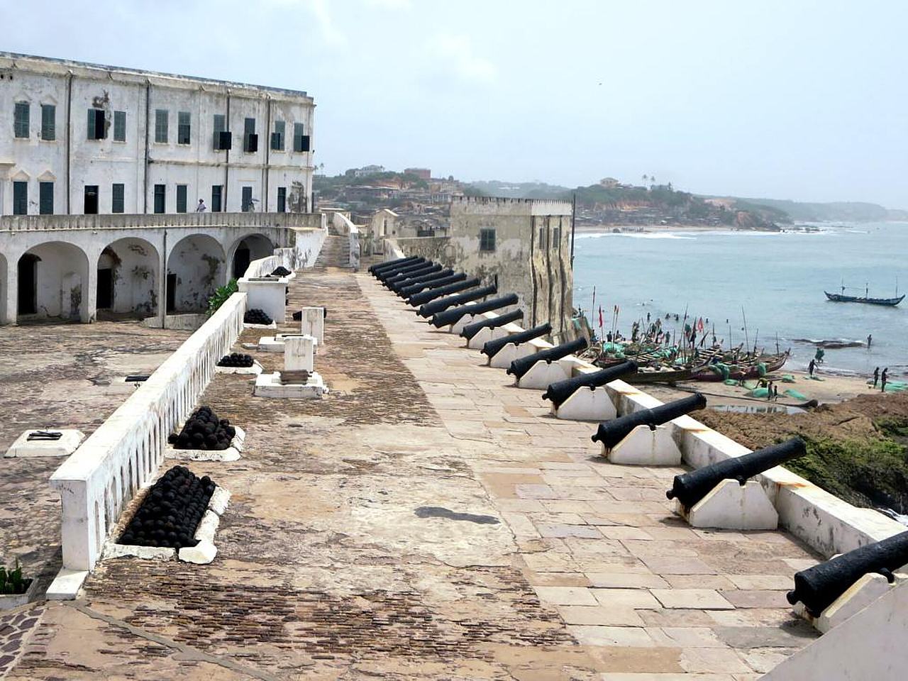 A row of cannon overlook the Gulf of Guinea from the Southeast Battery of Cape Coast Castle (1637), Ghana. The castle was originally used for trade in timber and gold and only later did it become the largest slave-trading center in West Africa.