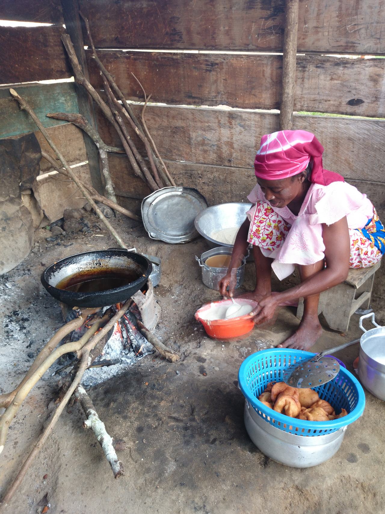 The koko seller mixes the ingredients in making agawu and prepares to drop spoonfuls into the oil for frying