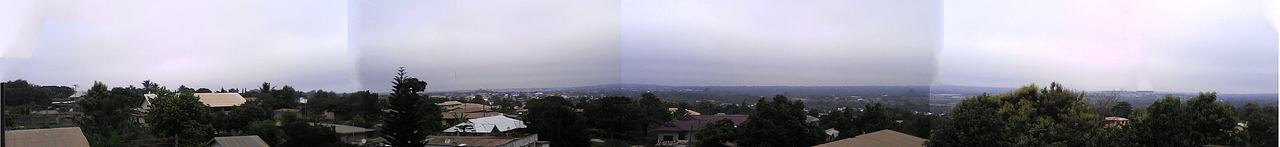 Techiman, Ghana, western skyline. The darker sky in the middle of the image results from assembly of four independent photographs. With the panorama capability of a digital camera, a better picture with a similar field of view is possible.