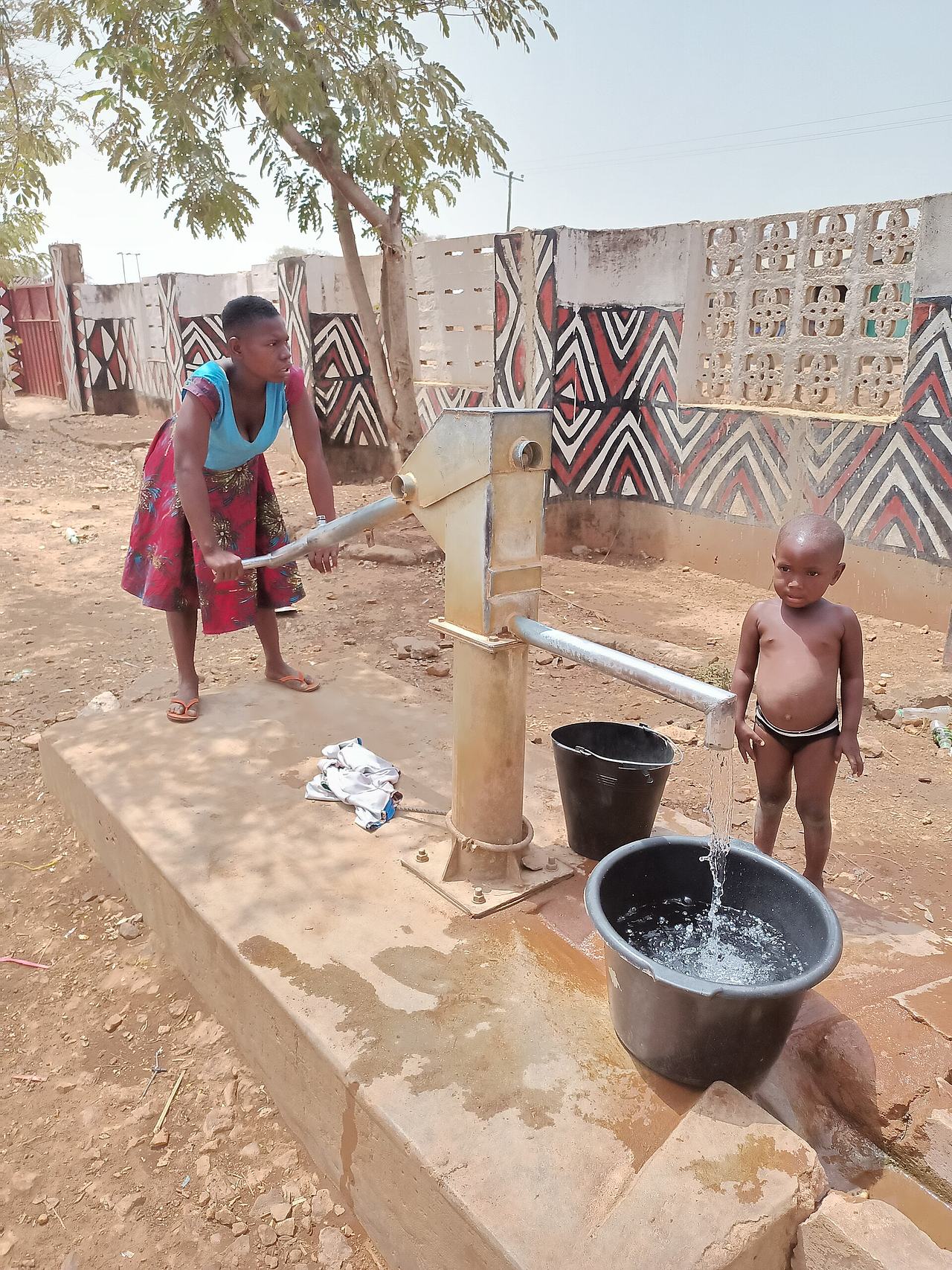 A lady fetching water from the borehole at sirigu(upper east of Ghana)