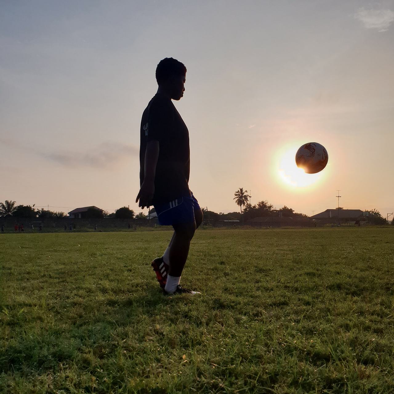 A self motivated female footballer trains by herself at sunrise