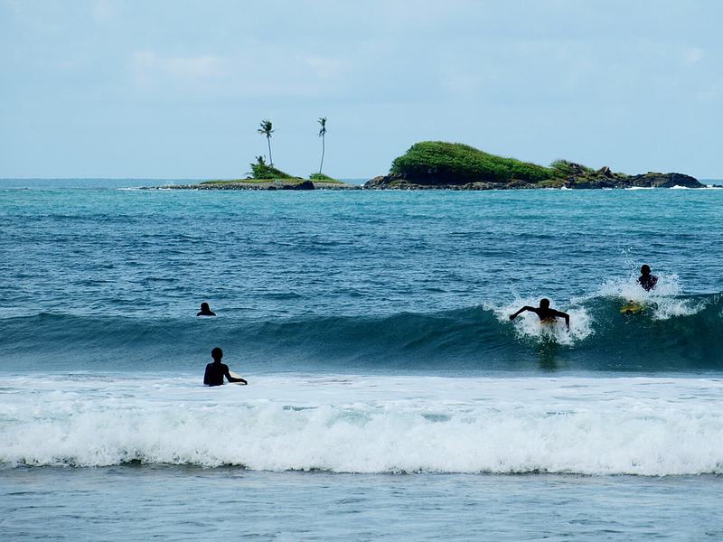 Surfers riding waves at Busua Beach, Ghana's surf destination.