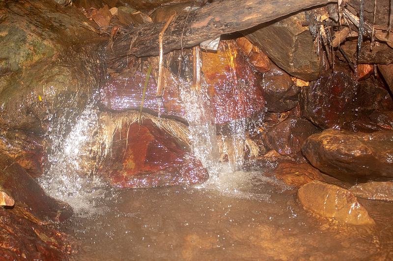 Water flowing out from between rocks at Obosomase Waterfalls