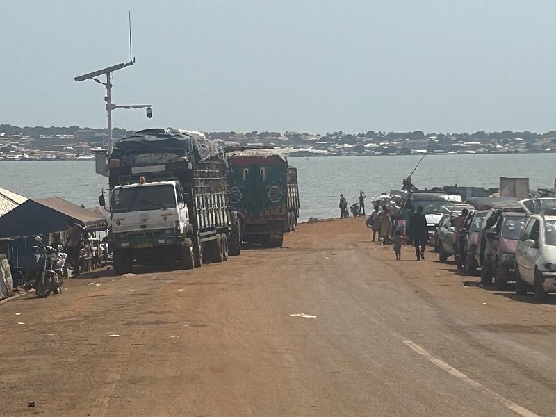 Vehicles and people waiting for the ferry to cross the Oti River at Dambai.