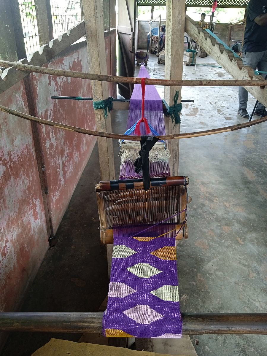 A weaver at work on a traditional kente loom in Tafi, Volta region, Ghana.