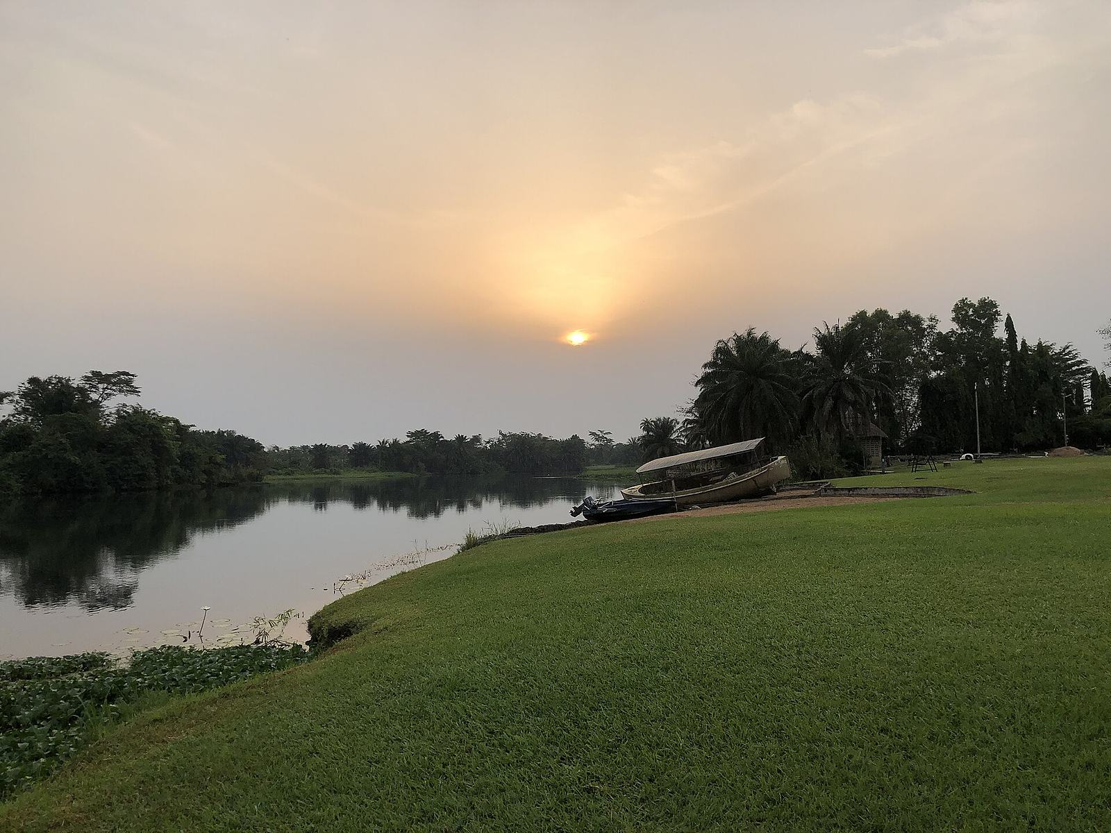 Benches beside the Volta River at The Royal Senchi hotel in Akosombo, Ghana, at sunrise.