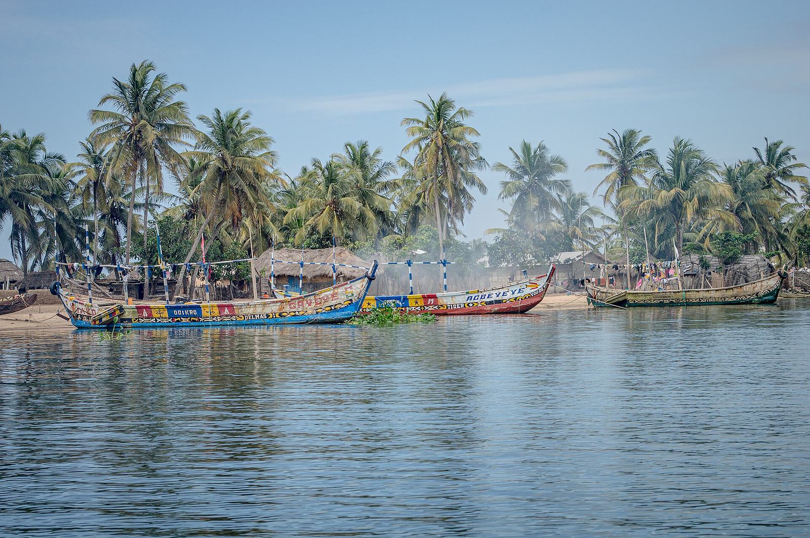 Palm-lined beach and estuary at Ada Foah, Ghana.